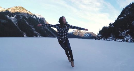 Woman Skates On Frozen Lake In The Mountains