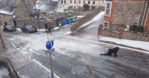 People Struggle To Walk On Ice-Covered Road