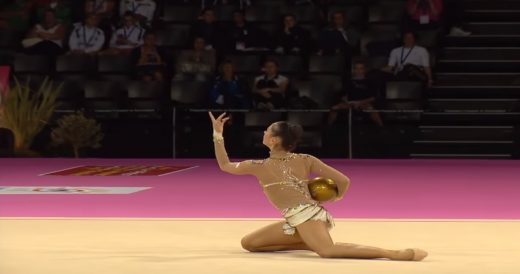 Gymnast Performs Shiny Golden Ball Routine