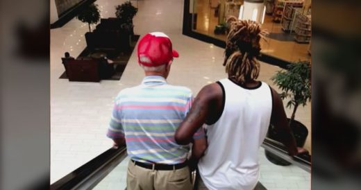 Young Man Helps Grandpa Go Down Escalator