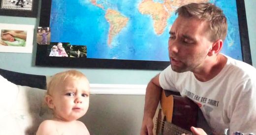 Dad Strums Guitar And Sings With Son